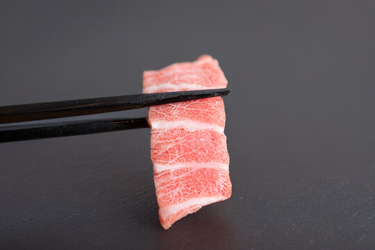 Tuna sashimi on chopsticks