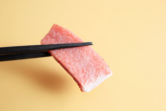 Tuna sashimi on chopsticks