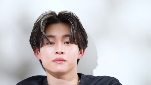 A stylish beauty video featuring a young man with a summer-like, sun-drenched look, showing trees swaying, with close-ups and slow-motion shots capturing a fresh, translucent men's beauty aesthetic