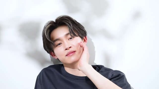 日射しの強い夏のような木が揺れる若い男性のお洒落な美容や爽やかで透明感のあるメンズビューティーイメージクローズアップ動画