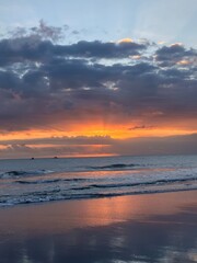 Fototapeta premium Colorful sunset over ocean waves with dramatic sky