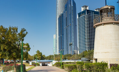 Obraz premium Modern towers rise beside a historic lighthouse