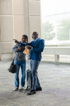 Hispanic son and african american dad in blazer asking for directions at terminal