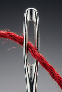 Macro Close-Up of Red Thread Passing Through Needle Eye