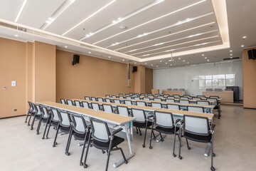 Fototapeta premium Modern tiered conference classroom interior with rows of desks and chairs