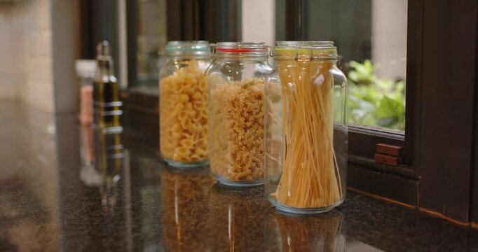 Shifting window light is causing focus shift, glass pasta jars are staying still for still life