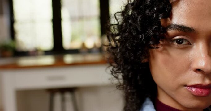 Non-binary person shifting from closeup to smiling and laughing in kitchen with counter, copy space