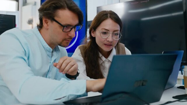 Programmer or software engineer team collaboration in tech training session.Professional programmer man and woman discussing coding on laptop screen for develop ai assistant project in modern office.