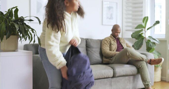 African American father and daughter entering living room unpacking backpack father tying her hair