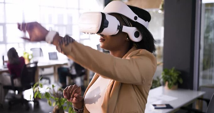 Upon hand rising, woman in VR headset at office desk is pinching, swiping to select options