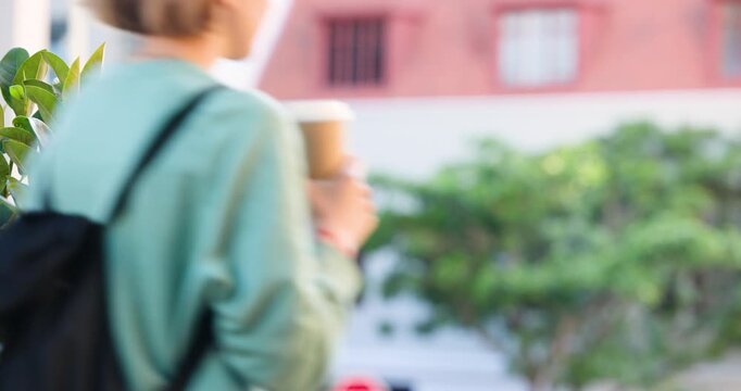 Shrub staying sharp in left front while pedestrians are entering frame walking on sidewalk to work
