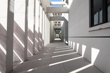 Naklejka premium Modern architectural corridor with intersecting light and shadow patterns