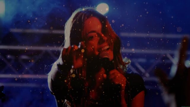 Lead singer holding mic, engaging crowd on concert stage, camera shifting sparking glitter