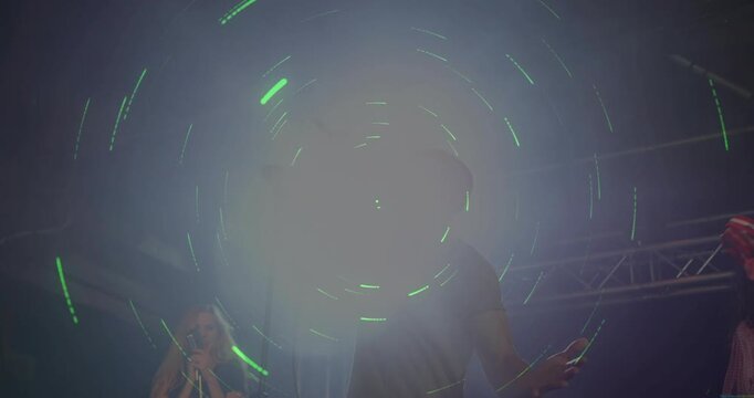 Vertical video: Singing singer in tee with mic on stage as lights rising, tambourine for climax