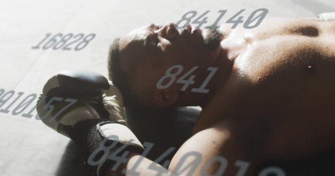 Male boxer postround resting, lying on mat breathing, numeric overlay tracking stats, gloves nearby