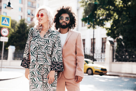 Beautiful fashion woman and her handsome elegant boyfriend in beige suit. Sexy blond model in summer suit clothes. Fashionable smiling couple posing in street Europe. Brutal man and female outdoors