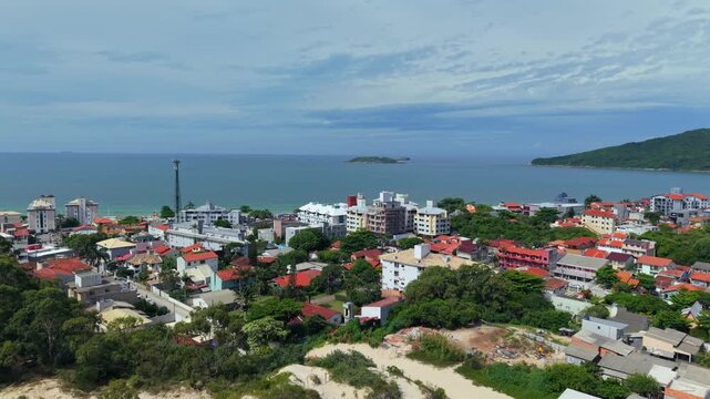 Sandy dunes and coastal town near Praia dos Ingleses and Ilha Mata Fome Florianopolis Santa Catarina Brazil, drone dolly