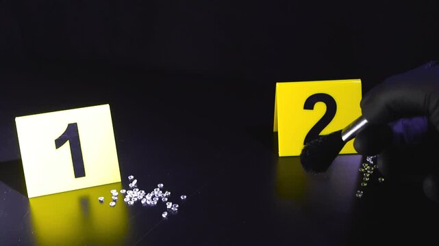 Gloved investigator dusts a dark surface beside numbered forensic markers and sparkling diamonds under dramatic studio light