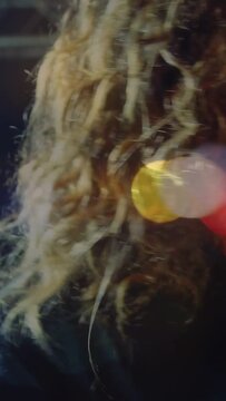 Vertical video: Male singer pressing mic and singing on music stage, moving bokeh adding raw energy