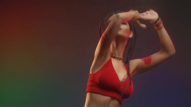Energetic Woman Dancing with Raised Arms Against a Vibrant Backdrop
