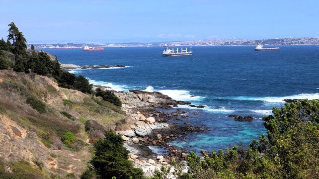 Panoramic view of El Tebo beach with turquoise waters and cargo ships in the Pacific Ocean, Chile