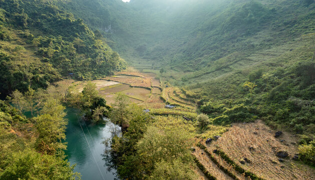Scenic view of the valley with rice fields and river in Hang Than Lim, Yen Minh, Ha Giang, Vietnam. The terraced fields are used for agriculture and are a vital part of the local economy.