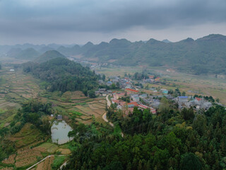 Obraz premium Aerial view of rice terraces in the mountains of Quan Ba, Ha Giang, Vietnam. The terraces are used to grow rice, a staple food . The mountains provide a scenic backdrop.