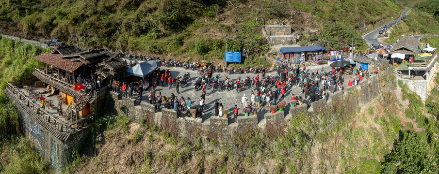 Aerial view of the Doc Tham Ma Pass, a winding mountain road in Ha Giang province, Vietnam. Tourists stop to enjoy the view and local food at a roadside cafe. Ha Giang, Vietnam.