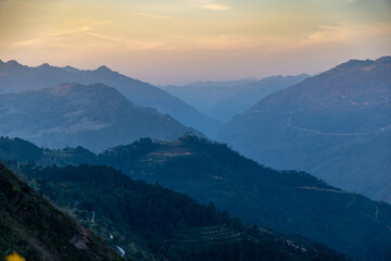 Fototapeta premium A scenic view of the mountain range in Dong Van, Ha Giang, Vietnam, showcasing the natural beauty and winding roads through the landscape at dusk.