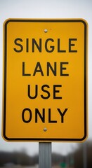 Fototapeta premium Yellow Warning Sign Single Lane Use Only Traffic Directional