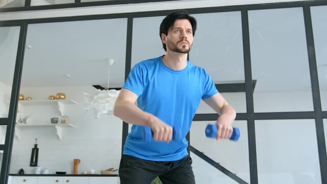 Portrait of active motivated good looking sporty fit man in sportswear practicing weight training , doing bent over dumbbell rows workout while exercising in domestic room.