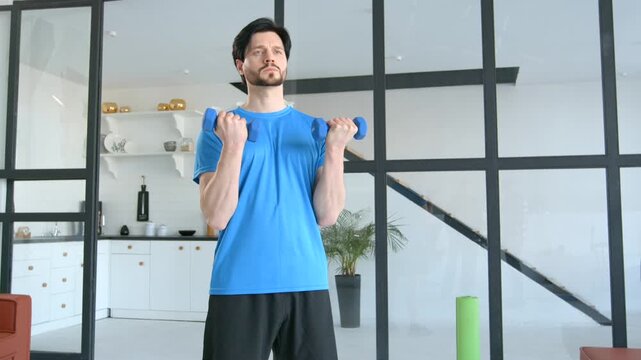 Motivated determined sporty muscular build man practicing dumbbell biceps curl workout, building strength in upper arm muscles and boosting athletic performance during indoors sports training .