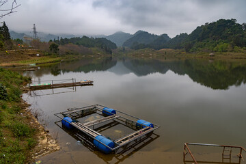 A pontoon floats on a lake in the mountains of Quan Ba, Ha Giang, Vietnam. © Zenstratus