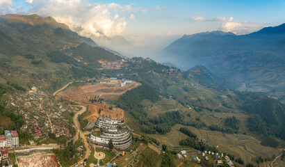 Aerial view of Sapa, Vietnam, showcasing the Hotel de la Coupole - MGallery, nestled in the mountains. The hotel stands out with its unique architecture and design. © Zenstratus