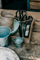 Rustic wooden table with vintage gardening tools, twine and buckets. High-angle flat lay view of a...