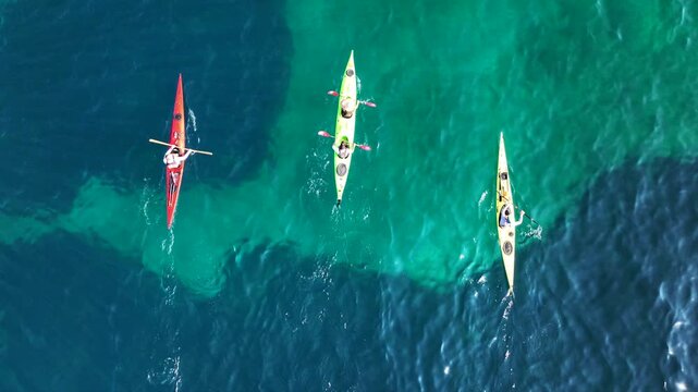 Aerial drone top down cinematic video of athletes practice sport canoe in tropical exotic island emerald crystal clear calm sea