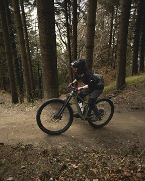 Biker riding through a dark forest path