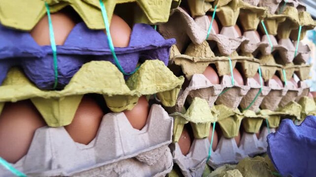A stack of brown eggs in colorful cartons slowly pans to the right, showing numerous neatly arranged rows