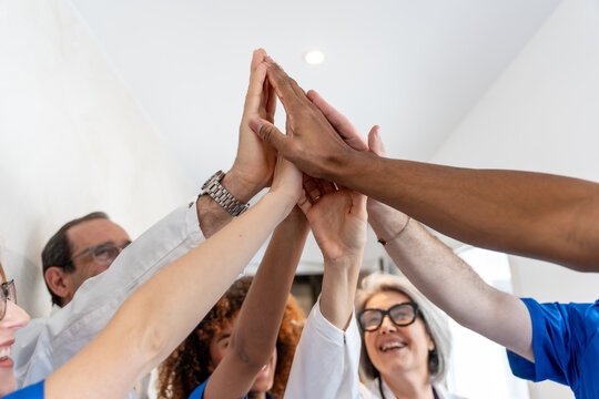 Diverse medical team joining hands for unity and success