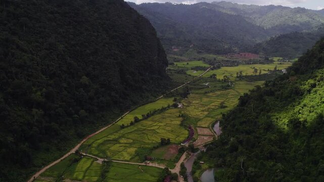 Very high altitude flying view of valley among tall mountainous tropical landscape