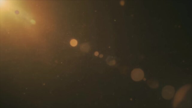 Warm golden lens flare and dust particles drifting in dark space.