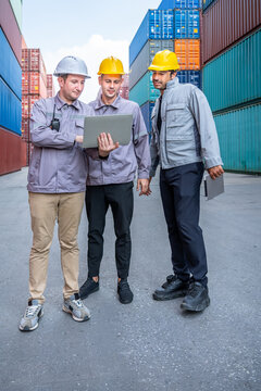 Engineer industrial workers males inspecting logistics using laptop and tablet in shipping container yard