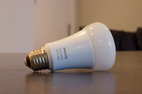Philips Hue white and color LED smart bulb lying on its side on a wooden surface