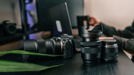 Naklejka premium Professional camera equipment and laptop on a dark wooden desk, ready for creative work