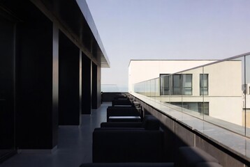Fototapeta premium Modern building with a balcony and seating area, suggesting relaxation or contemplation.