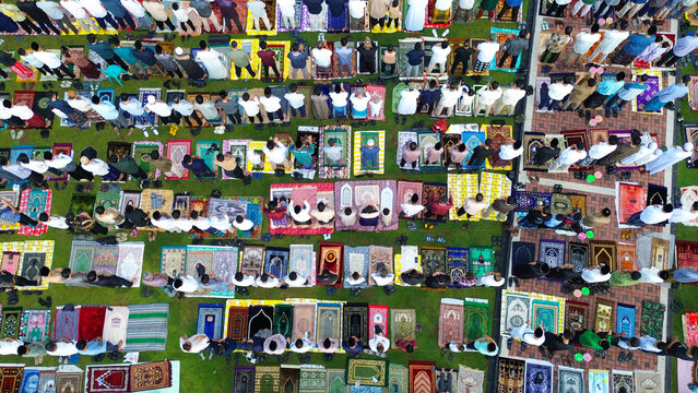 Aerial view shows many muslim people praying, Eid al Fitr prayer , Salah Eid al-Fitr on green grass indonesia
