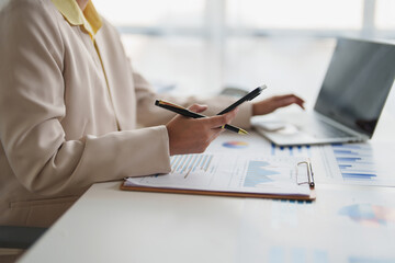 Business professional analyzing financial data with smartphone laptop