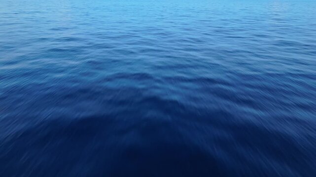 Aerial drone view of calm tropical ocean with smooth mirror surface and dramatic cloudy sky
