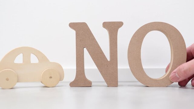 車利用を否定するNOサインと木製おもちゃ。