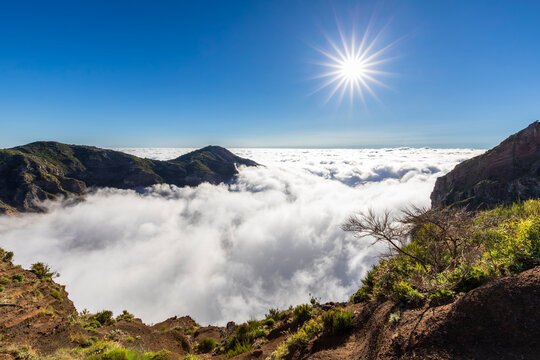 Scenic sunlit view over clouds on hiking trail Pico do Areeiro Madeira